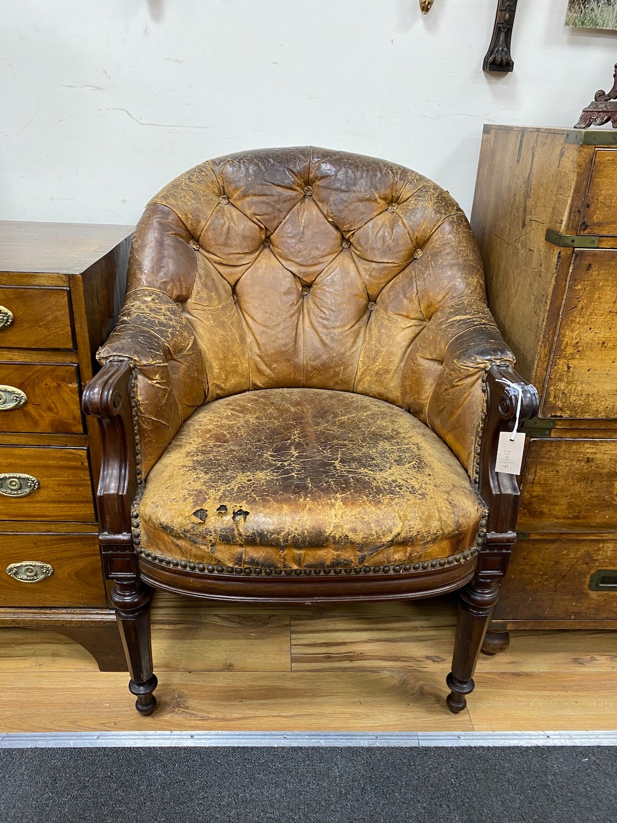 An early Victorian buttoned brown leather mahogany library chair, width 65cm, depth 62cm, height 86cm